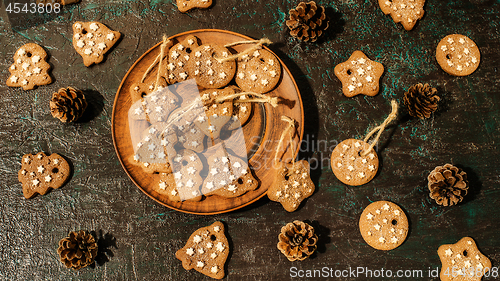 Image of Christmas theme with cookies, spruce cones on a dark background. Flat lay.