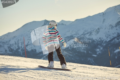 Image of Female snowboarder in sun flare