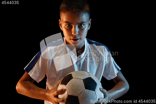 Image of Young boy as a soccer or football player on dark studio background