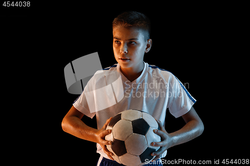 Image of Young boy as a soccer or football player on dark studio background