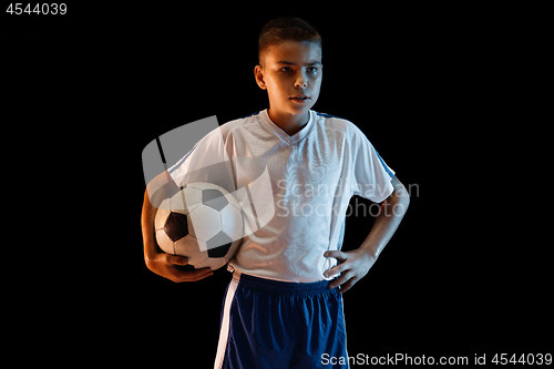 Image of Young boy as a soccer or football player on dark studio background