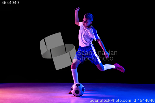 Image of Young boy as a soccer or football player on dark studio background