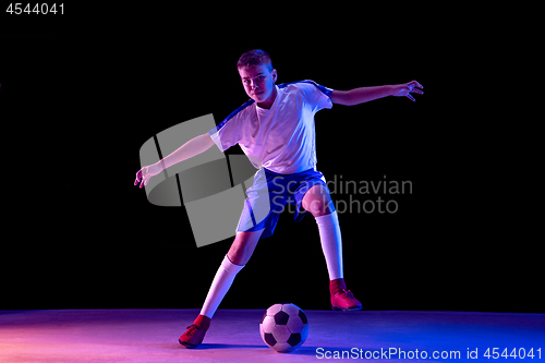 Image of Young boy as a soccer or football player on dark studio background