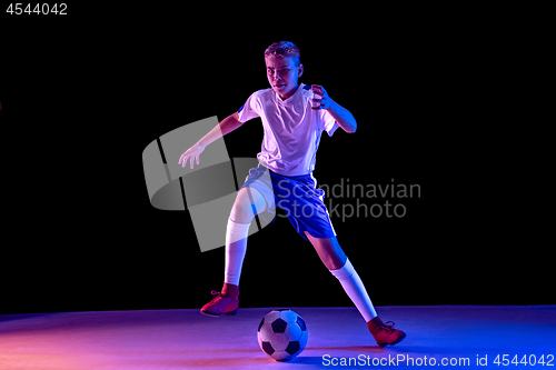 Image of Young boy as a soccer or football player on dark studio background