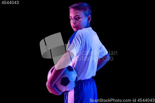 Image of Young boy as a soccer or football player on dark studio background