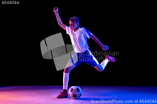 Image of Young boy as a soccer or football player on dark studio background