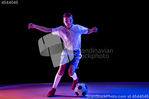 Image of Young boy as a soccer or football player on dark studio background