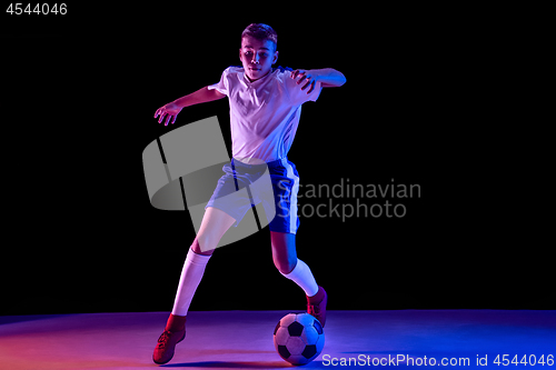 Image of Young boy as a soccer or football player on dark studio background