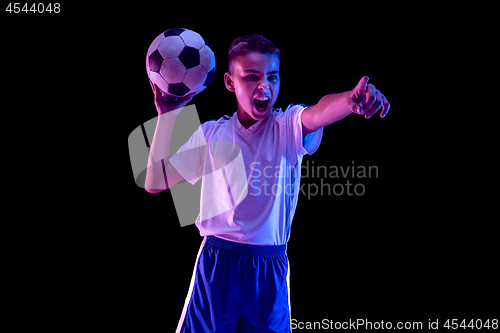 Image of Young boy as a soccer or football player on dark studio background
