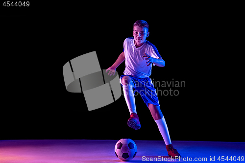 Image of Young boy as a soccer or football player on dark studio background