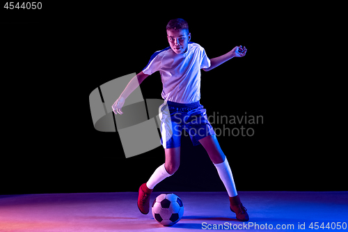 Image of Young boy as a soccer or football player on dark studio background