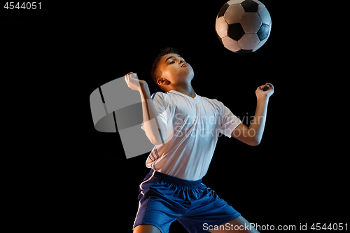 Image of Young boy as a soccer or football player on dark studio background