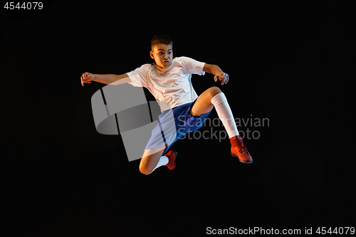 Image of Young boy as a soccer or football player on dark studio background