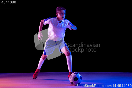 Image of Young boy as a soccer or football player on dark studio background