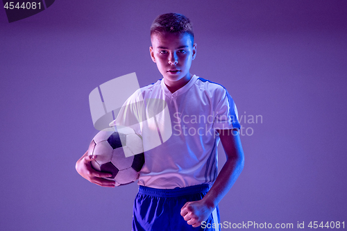 Image of Young boy as a soccer or football player on dark studio background