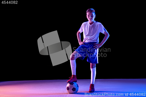 Image of Young boy as a soccer or football player on dark studio background