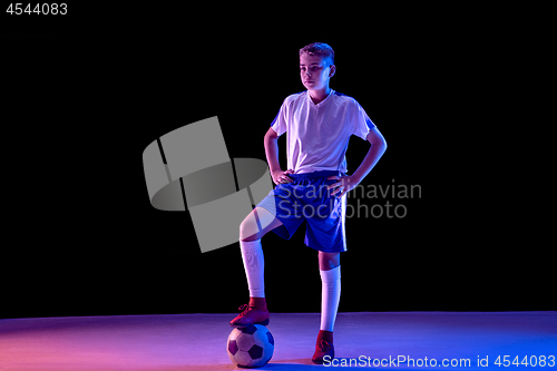 Image of Young boy as a soccer or football player on dark studio background