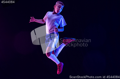 Image of Young boy as a soccer or football player on dark studio background