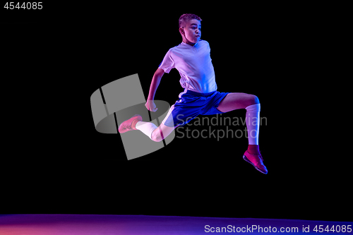 Image of Young boy as a soccer or football player on dark studio background