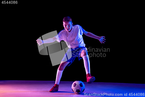 Image of Young boy as a soccer or football player on dark studio background