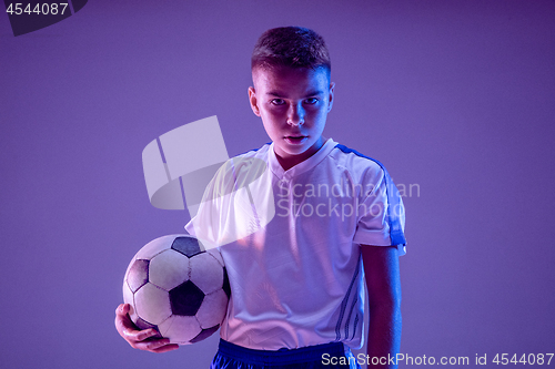 Image of Young boy as a soccer or football player on dark studio background