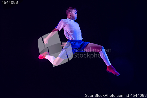 Image of Young boy as a soccer or football player on dark studio background