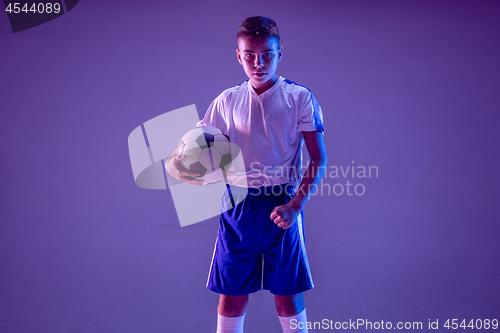 Image of Young boy as a soccer or football player on dark studio background