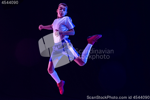 Image of Young boy as a soccer or football player on dark studio background