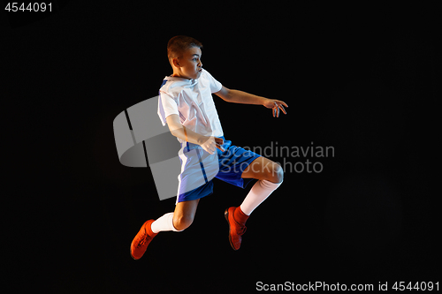 Image of Young boy as a soccer or football player on dark studio background