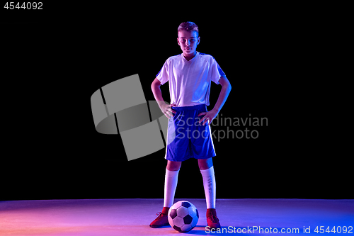 Image of Young boy as a soccer or football player on dark studio background