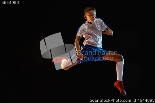 Image of Young boy as a soccer or football player on dark studio background