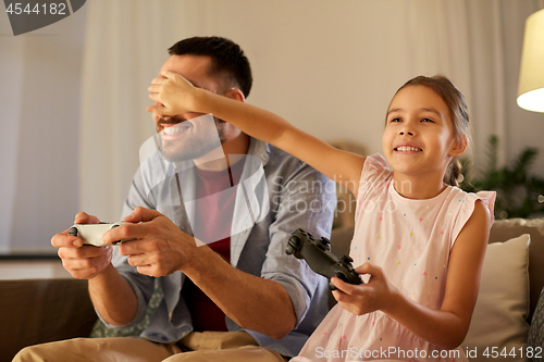Image of father and daughter playing video game at home