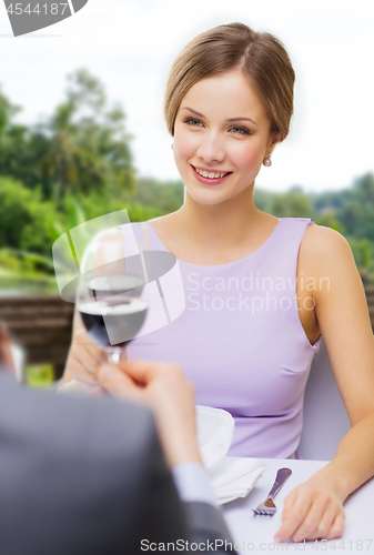 Image of woman drinking wine with her man at restaurant