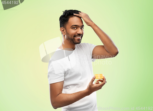 Image of indian man applying hair wax or styling gel