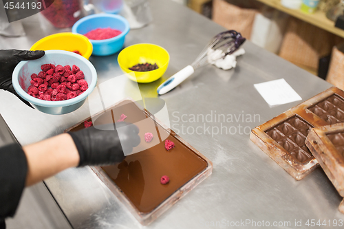 Image of confectioner makes chocolate dessert at sweet-shop