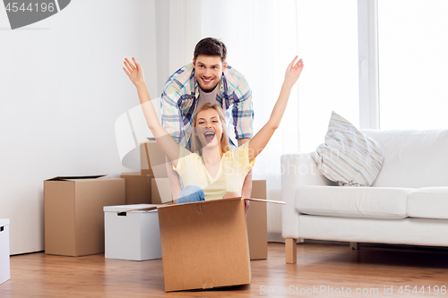 Image of happy couple having fun with boxes at new home