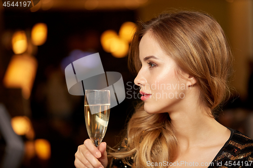 Image of woman with glass of champagne at night club