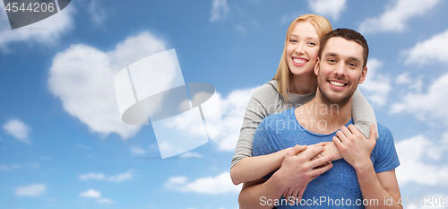 Image of couple hugging over sky and heart shaped cloud