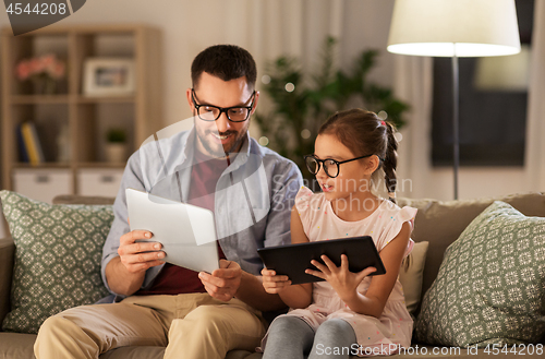 Image of father and daughter with tablet computers at home