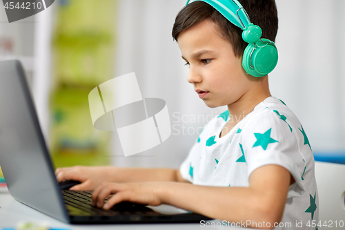 Image of boy in headphones playing video game on laptop