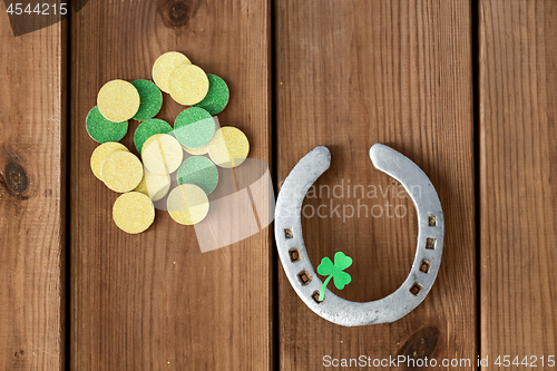 Image of horseshoe with shamrock on wooden background