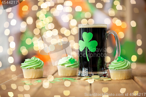 Image of shamrock on glass of beer, green cupcake and coins