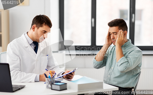 Image of doctor and male patient having headache at clinic