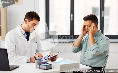 Image of doctor and male patient having headache at clinic