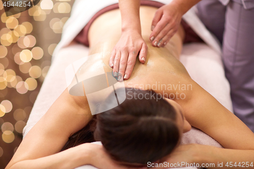 Image of woman having back massage with gel at spa