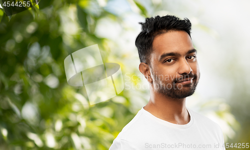 Image of smiling young indian man over gray background