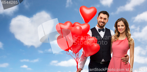 Image of happy couple with red heart shaped balloons