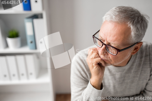 Image of close up of senior man in glasses thinking