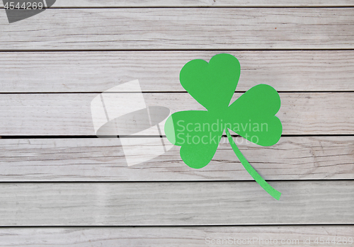 Image of green paper shamrock on wooden background