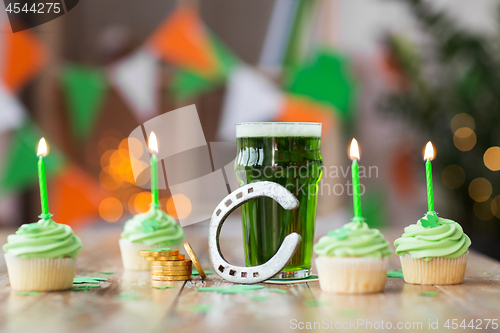 Image of glass of beer, cupcakes, horseshoe and gold coins